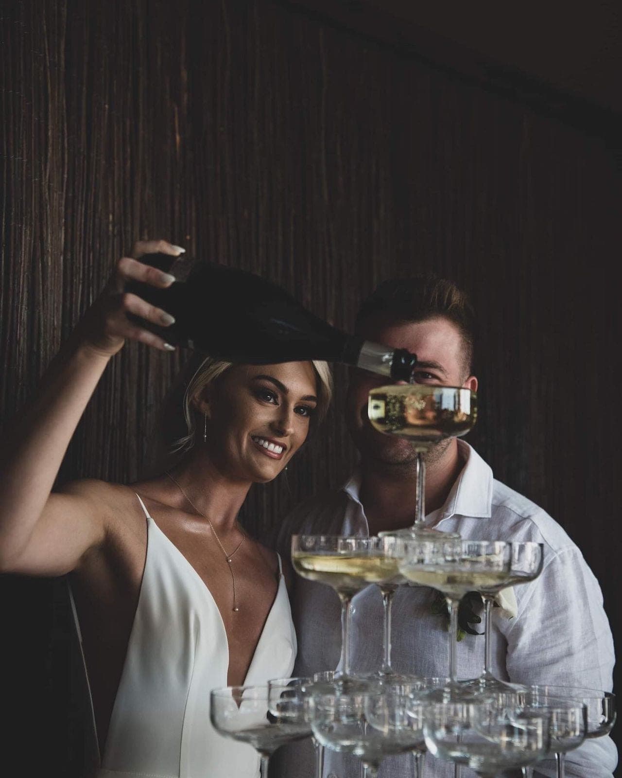 Couple pouring a champagne tower
